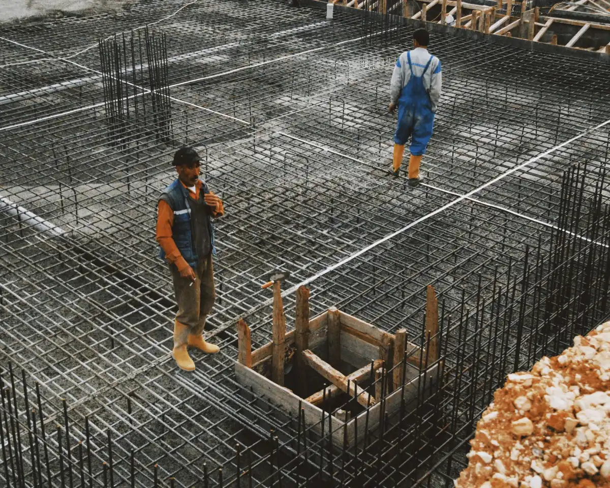 A large grid of tied reinforcing bar covering a prepared foundation area, with a formed column footing box set within it.