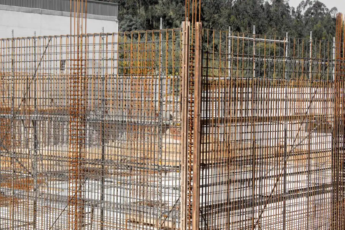 Vertical reinforcing steel cages standing in place for foundation walls, tied and positioned before the wall forms are closed.