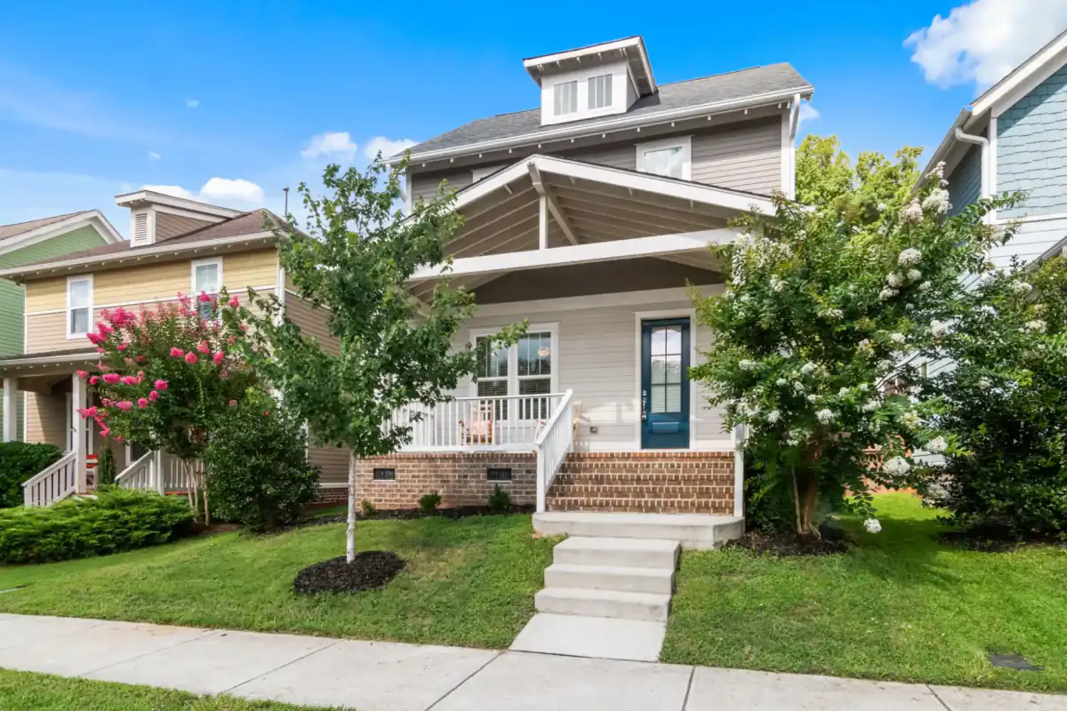 A set of concrete front entry steps leading up to a covered porch on a suburban house, with a concrete walk running from the steps out to the public sidewalk.