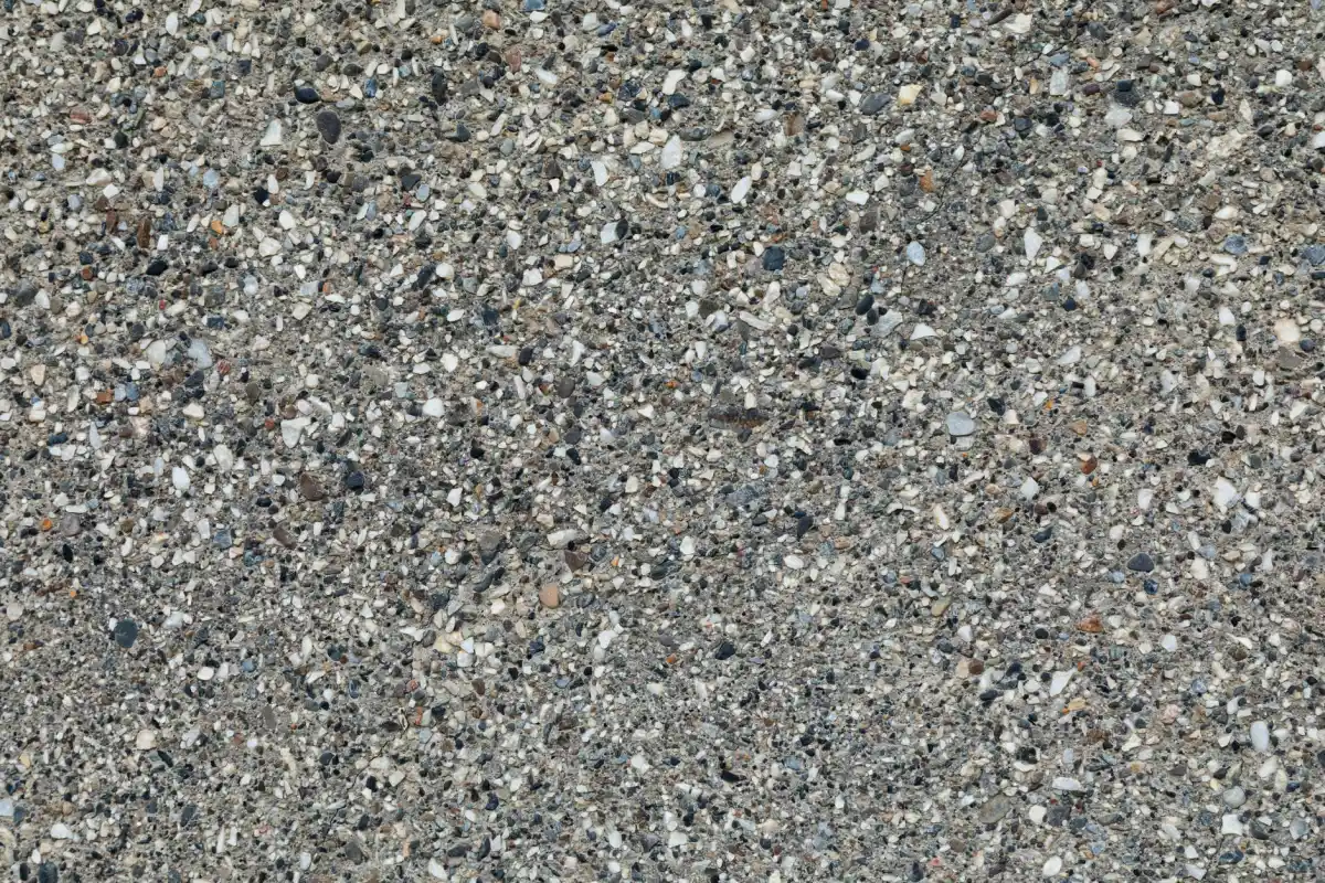 A concrete surface with fine stone exposed evenly across it, showing the colour and texture variation a decorative finish carries.