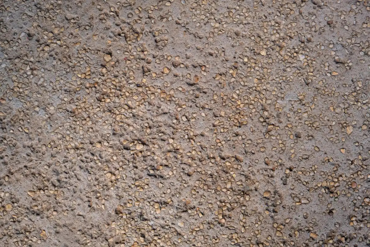 A fine exposed aggregate concrete surface in warm tones, the stone sitting proud of the paste after the surface has been washed back.