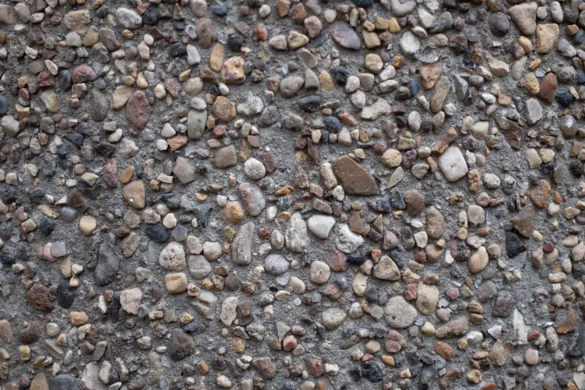 A close view of an exposed aggregate concrete surface with large rounded pebbles washed clear of the surrounding paste.