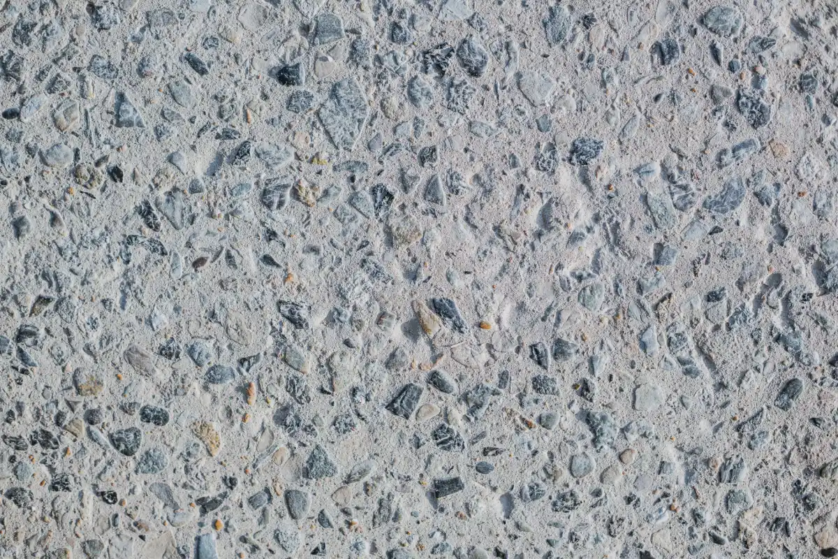 A close view of a decorative concrete surface showing fine exposed stone in a blue-grey matrix, the kind of texture and colour variation a decorative finish is judged on.
