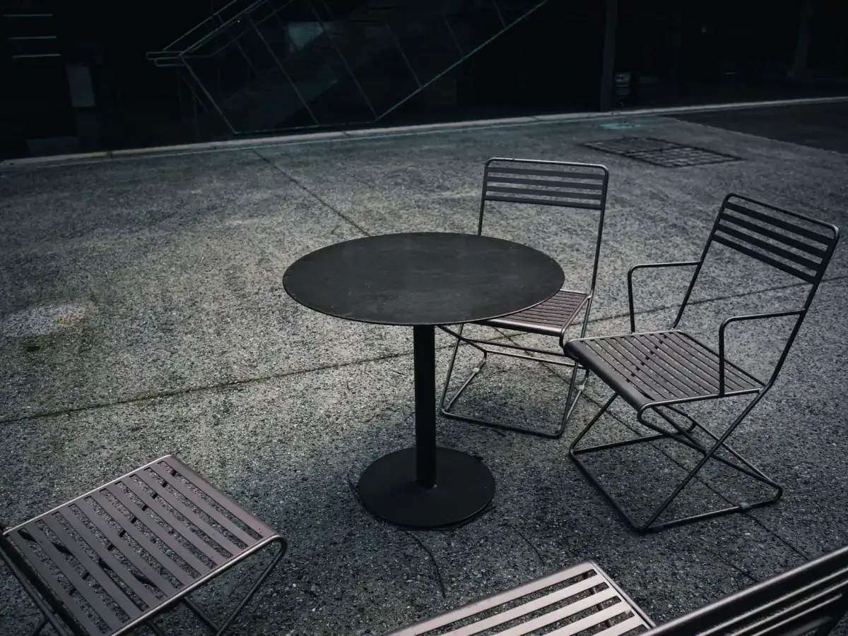 Outdoor furniture standing on a textured decorative concrete patio, showing how a patterned surface reads at the scale people actually sit on.